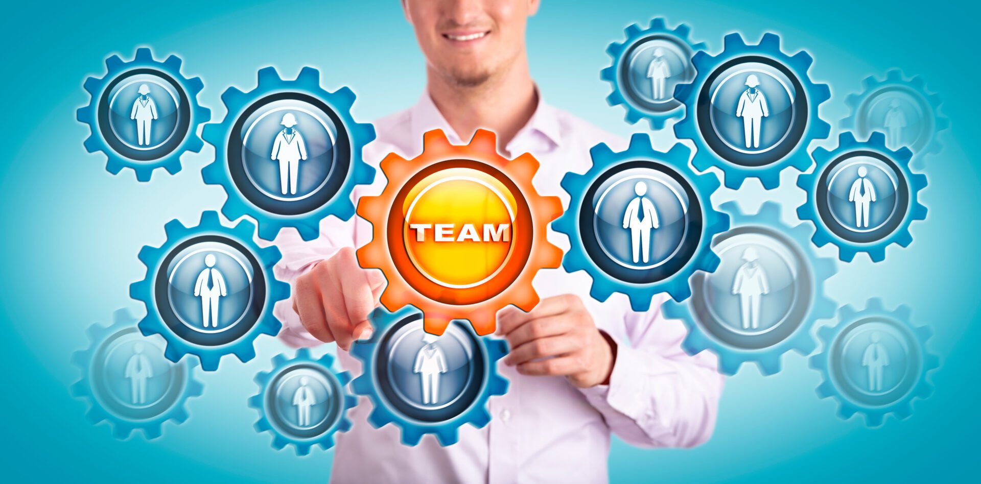 Young smiling man in shirt touching a virtual cogwheel labeled TEAM in a gear train of employees. Human resources concept for team building, teamwork, talent development, recruitment, HRM, strategy.